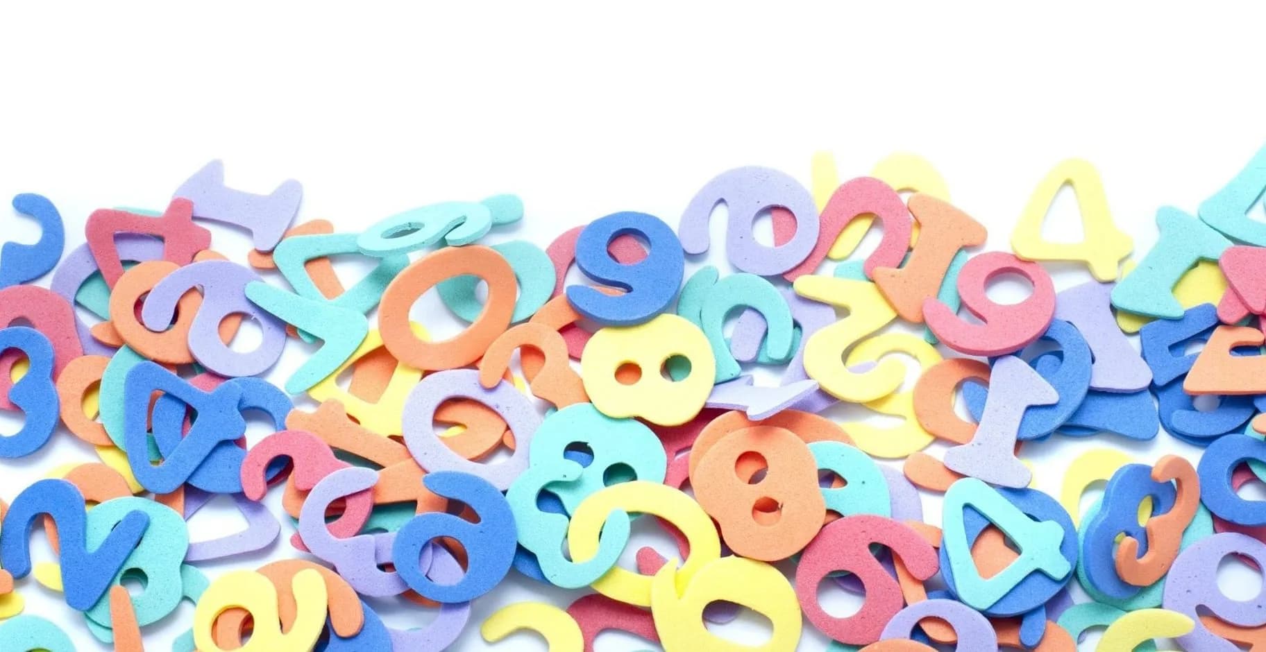 Foam number shapes in pastel colours scattered across a white background.